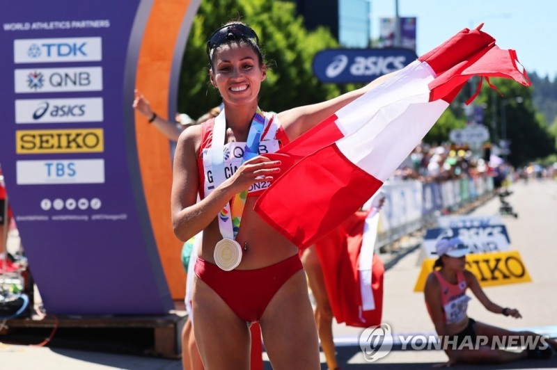 (유진 EPA=연합뉴스) 킴벌리 가르시아가 16일(한국시간) 미국 오리건주 유진에서 열린 2022 세계육상선수권대회 여자 20㎞ 경보 결선에서 우승한 뒤, 페루 국기를 펼치고 있다.