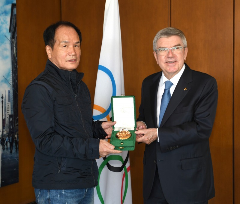 토마스 바흐 IOC 위원장(오른쪽)이 스포츠전문 사진 작가 김민제씨에게 쿠베르탱 메달을 수여한 뒤 기념촬영을 하고 있다. IOC의 3대 상훈 가운데 하나인 쿠베르탱 메달은 지금까지 30여명밖에 수상하지 못했다. 김민제는 우리나라 최초 수상자다