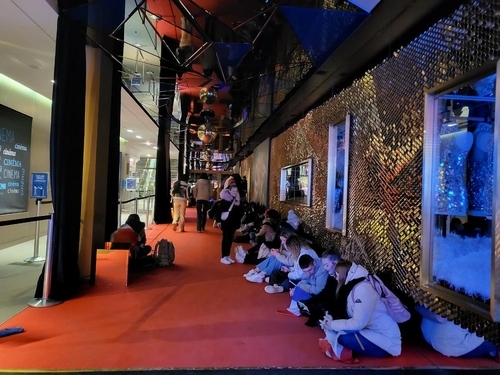 월드컵 결승전이 열린 18일(현지시간) 오후 프랑스 파리 샹젤리제 거리에 있는 한 영화관에서 사람들이 바닥에 앉아 스마트폰으로 중계를 보고 있다. [사진=연합뉴스] 