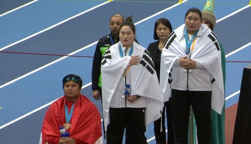 정유선(가운데)이 11일 카자흐스탄 아스타나에서 열린 제10회 아시아실내육상선수권 여자 포환던지기 결선에서 우승한 뒤, 시상식에서 애국가를 부르고 있다. 오른쪽은 은메달을 딴 이수정. [카자흐스탄육상연맹 제공]