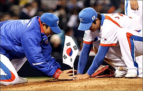 마운드에 태극기를 꽂고 있는 한국 선수들.