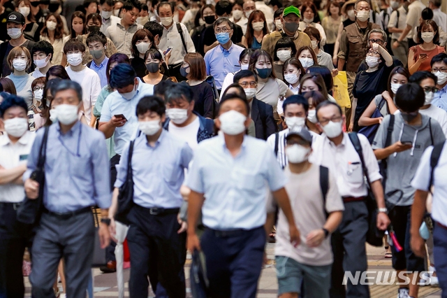신종 코로나바이러스 감염증(코로나19) 예방을 위해 마스크를 쓴 사람들이 지난 29일 일본 오사카의 도로를 걷고 있다. 