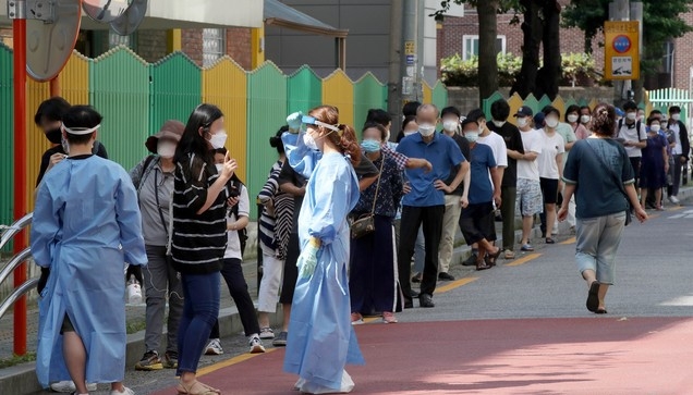 보성운수 시내버스 기사 3명이 코로나19 확진 판정을 받은 가운데 24일 오전 서울 구로구 보건소에 마련된 선별진료소를 찾은 시민들이 줄을 서 기다리고 있다.