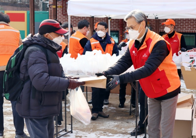(사진=SK이노베이션) 지난 5일, SK에너지 조경목 사장(오른쪽)이 참여한 ‘명동밥집’ 봉사활동에서 도시락과 명절 선물을 전달했다.
