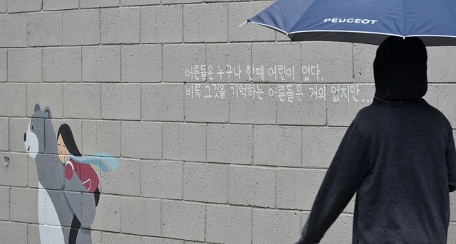봄비가 내린 12일 오후 대구 중구 삼덕동 벽화 길에서 한 시민이 우산을 쓴 채 걸어가고 있다. 