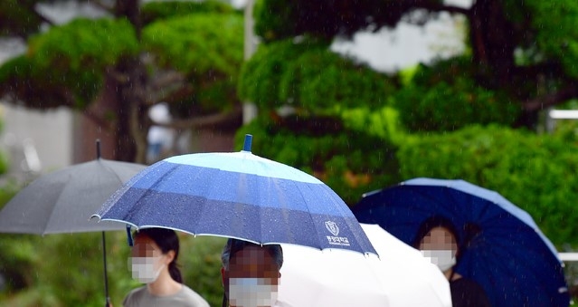 장맛비가 내리는 5일 오후 광주 동구 전남대학교병원에서 시민들이 우산을 쓴 채 발걸음을 옮기고 있다.