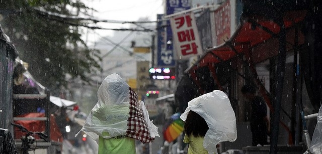 소나기가 내린 지난달 19일 오후 서울 중구 황학동 주방거리 인근에서 어린이들이 비닐봉지를 머리에 쓰고 발걸음을 재촉하고 있다.