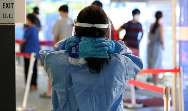 연일 폭염이 계속되는 4일 오전 서울 동작구보건소 선별진료소에서 의료진이 얼음주머니로 더위를 식히고 있다.