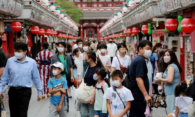 13일 일본 도쿄 아사쿠사 나카미세 상점가에서 마스크를 착용한 시민들이 활보하고 있다.  도쿄에서만 2만 명 넘는 코로나19 환자가 병상을 찾지 못해 집에서 요양하는 등 의료 붕괴가 현실화하는 것 아니냐는 우려가 커지고 있다.
