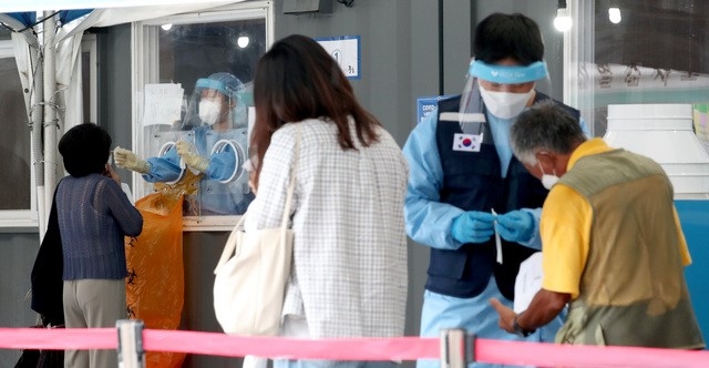 코로나19 일일 신규 확진자 수가 1,805명으로 집계된 18일 오전 서울 중구 서울역에 마련된 임시선별검사소에서 시민들이 검사를 기다리고 있다. 