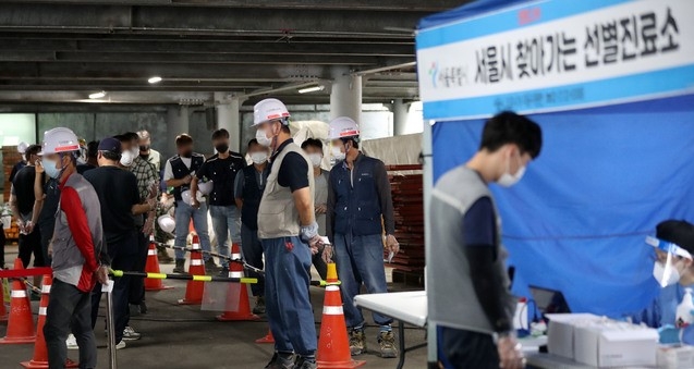 지난 20일 오후 서울 중구 앰배서더호텔 리모델링 공사현장에서 건설노동자들이 검사를 위해 대기하고 있다. 