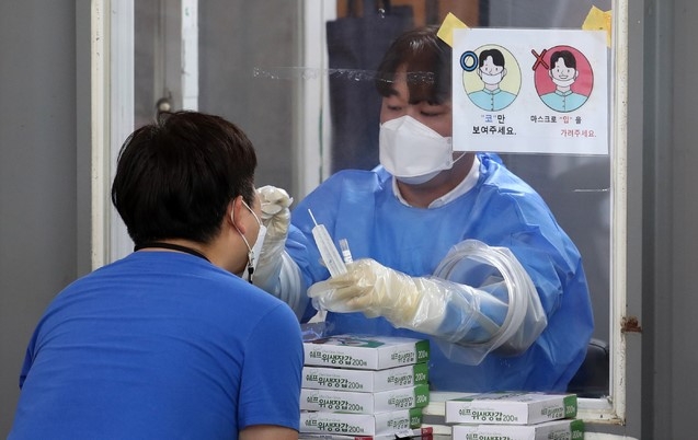 지난 22일 오후 서울 관악구 보건소 선별진료소에서 의료진이 검체 채취를 하고 있다. 