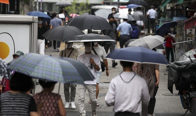  비가 내리고 있는 23일 오후 서울 중구 남대문시장에서 우산을 쓴 시민들이 발걸음을 옮기고 있다. 