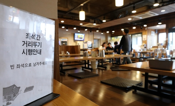 정부가 현행 거리두기를 2주 더 연장한다고 밝힌 지난 4일 오후 서울 시내 한 식당에 좌석 간 거리두기 안내문이 놓여 있다.
