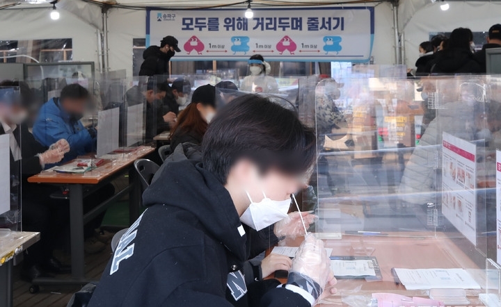 코로나19 신규 확진자가 5만4941명으로 역대 최다를 기록한 12일 오전 서울 송파구 보건소 선별진료소에서 시민들이 신속항원검사를 받고 있다.