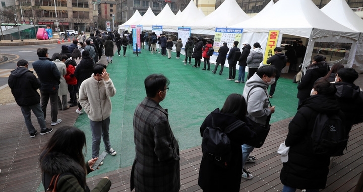 지난 14일 오전 서울 송파구 선별진료소에서 시민들이 코로나19 검사를 받기 위해 길게 줄지어 서 있다.