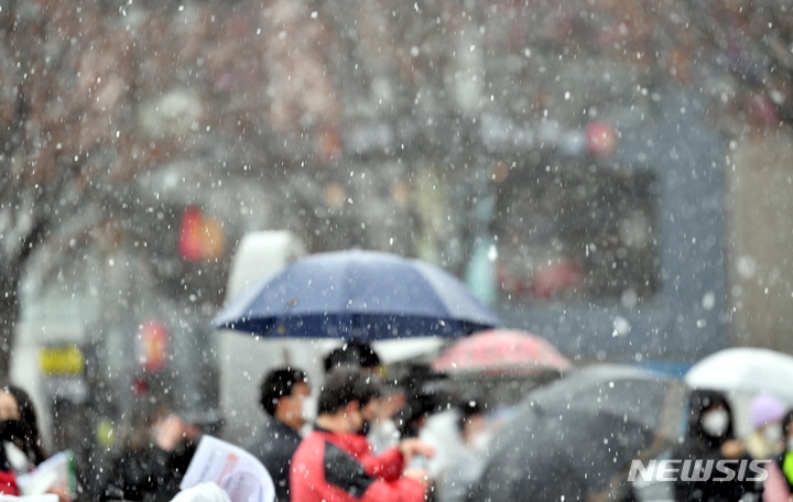 광주와 전남지역에 눈이 내리는 등 날씨가 추워진 가운데 1일 오전 광주 동구 5·18민주광장에서 시민들이 우산을 쓴 채 행사를 지켜보고 있다.