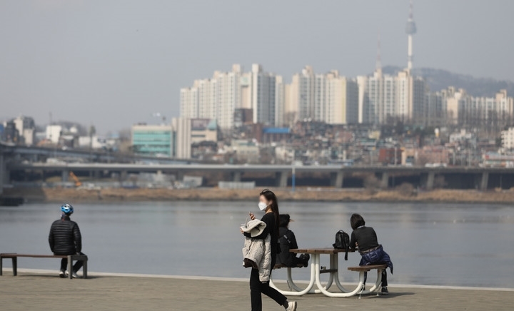 낮 최고기온이 20도 까지 오르는 등 따뜻한 봄 날씨를 보인 11일 오후 서울 서초구 반포한강공원에서 시민이 겉옷을 들고 이동하고 있다.
