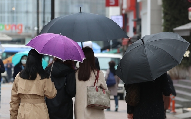 전국에 봄비가 내리기 시작한 지난해 3월 12일 서울 명동 거리에서 시민이 우산을 쓰고 있다