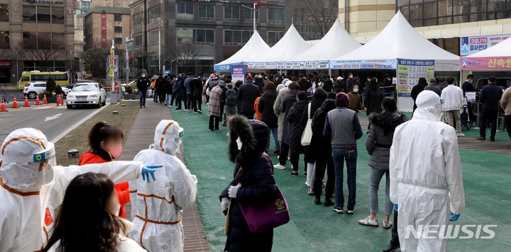 지난 15일 오전 서울 송파구 보건소 선별검사소에서 PCR과 신속항원 검사를 받으려는 시민들이 줄서 기다리고 있다.
