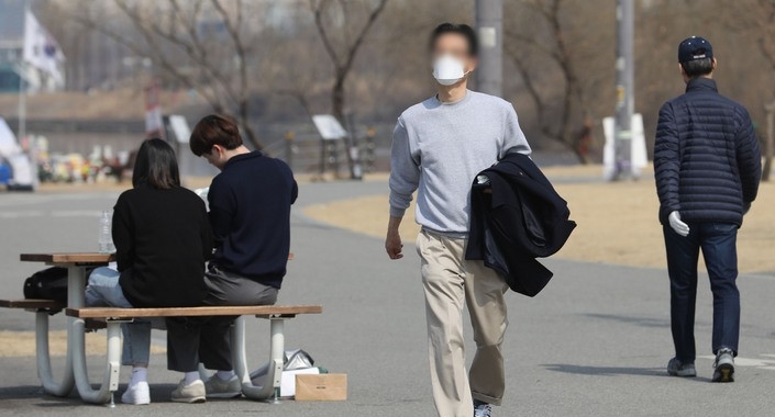 낮 최고기온이 20도 까지 오르는 등 따뜻한 봄 날씨를 보인 지난달 11일 서울 서초구 반포한강공원에서 시민이 겉옷을 들고 이동하고 있다. 