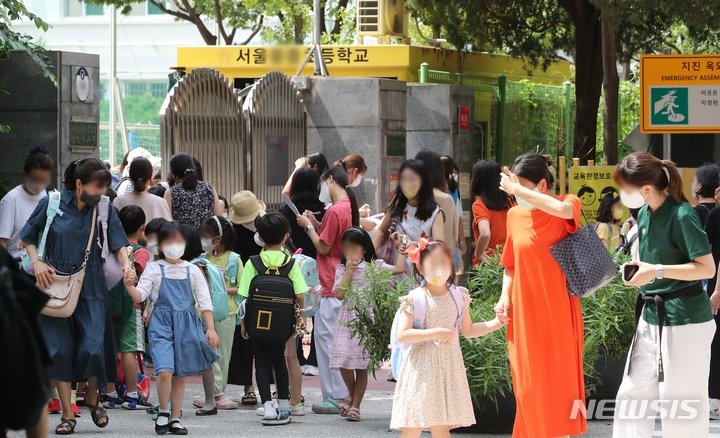 코로나19 하루 확진자 수가 126일만에 최다인 18만803명을 기록한 17일 오후 서울 시내 한 초등학교에서 수업을 마친 학생들과 보호자들이 하교하고 있다. 코로나19 재확산 속에 개학을 맞은 학생과 보호자들의 우려가 커지고 있다.(사진=뉴시스)