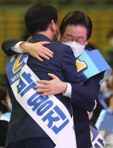 이재명(오른쪽) 더불어민주당 신임 당대표가 28일 서울 송파구 올림픽공원 체조경기장에서 열린 민주당 제5차 정기전국대의원대회에서 당대표로 선출된 뒤 박용진 당대표 후보와 포옹을 하고 있다.(뉴시스)