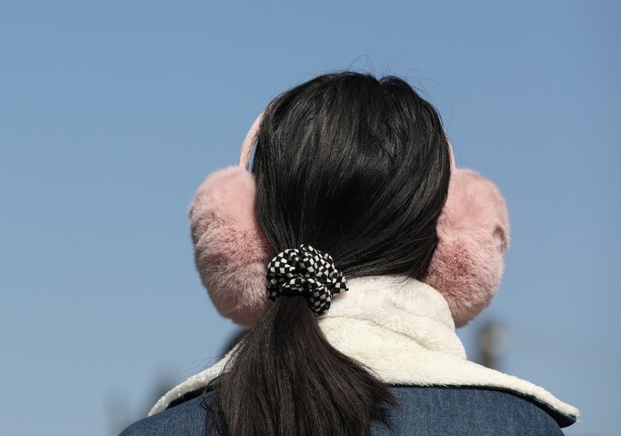 다시 추위가 찾아온 지난 21일 서울 종로구 세종대로사거리에서 귀마개를 착용한 시민이 이동하고 있다. 