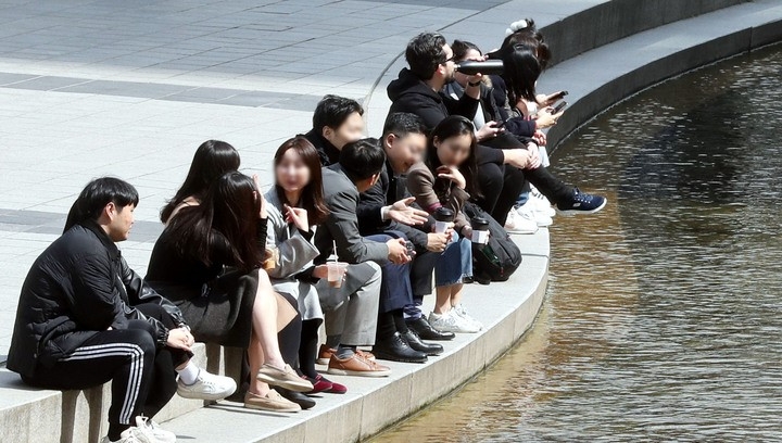 완연한 봄 날씨를 보이는 지난 20일 오후 서울 중구 청계천에서 시민들이 이야기를 나누고 있다.  