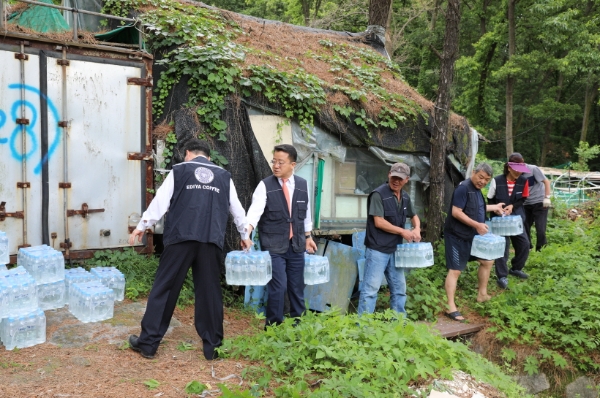 지난 12일 서울시 강남구에 위치한 구룡마을에서 이디야커피 관계자들이 주민들의 폭염 대비를 위한 이디야워터를 운반하고 있다.
