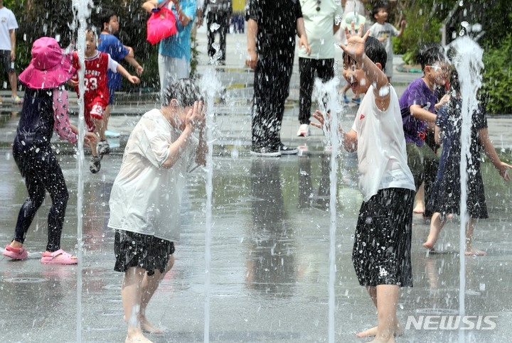  지난 6일 오후 서울 종로구 광화문 광장 분수대에서 어린이들이 물놀이를 하며 더위를 식히고 있는 모습. 