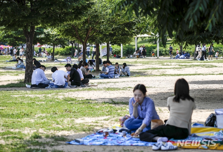 지난 6일 오후 서울 영등포구 여의도 한강공원을 찾은 시민들이 그늘에서 즐거운 시간을 보내고 있는 모습.