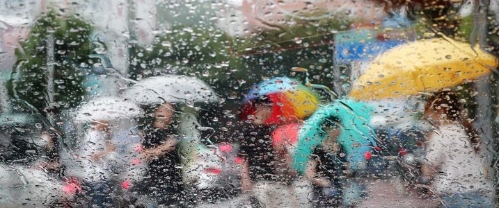  장맛비가 내리는 26일 부산 남구의 한 횡단보도에서 시민들이 우산을 쓴 채 발걸음을 재촉하고 있다.