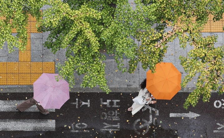 비가 내리고 있는 지난 13일 오후 서울 종로구 광화문역 인근에서 시민들이 우산을 쓰고 이동하는 모습.