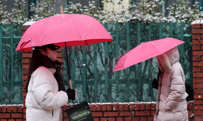 서울 등 수도권에 대설주의보가 내려진 9일 서울 마포구 공덕동 거리에서 시민들이 우산을 쓰고 발걸음을 재촉하는 모습.