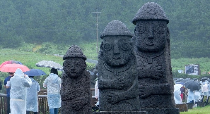 제주 서귀포시 대정읍 송악산에 우산을 쓴 관광객들이 걸어가고 있다.