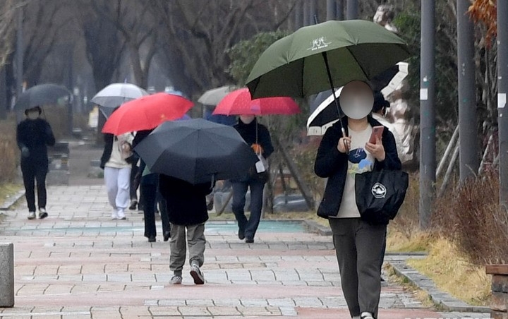 광주 서구 치평동 도심 공원에서 시민들이 우산을 쓴 채 걷고 있다.