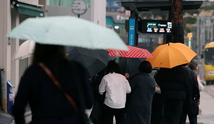 서울지역에 비가 내린 19일 서울 충무로역 인근에서 우산을 쓴 직장인들이 출근길 걸음을 재촉하고 있다.