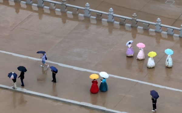 전국에 비가 내린 지난 5일 오후 서울 종로구 광화문 월대에서 우산을 쓴 관광객들이 기념사진을 찍고 있다. 