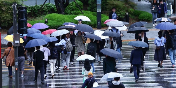 비가 내리는 지난달  24일 오전 서울 용산역 인근에서 시민들이 우산을 쓰고 출근길에 나서고 있다. 