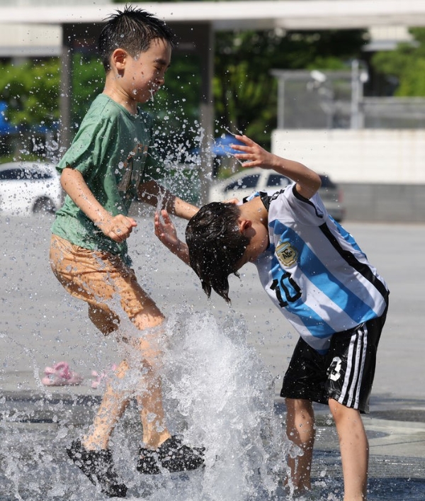  낮 최고기온이 32도를 넘어서는 등 무더위가 이어진 지난 13일 오후 서울 종로구 광화문광장 분수대에서 어린이들이 무더위를 식히고 있다. 