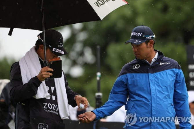 2라운드 경기 중 캐디에게서 볼 받는 마쓰야마<br /> [AFP=연합뉴스]