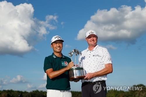 우승 트로피를 들어 보이는 케빈 나와 제이슨 코크랙<br /> [게티이미지/AFP=연합뉴스]