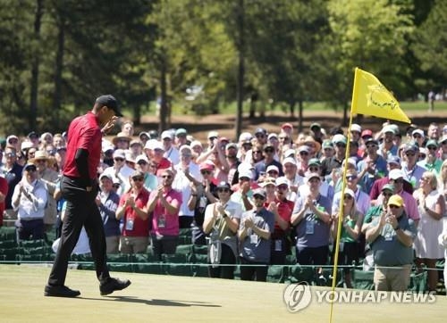 마스터스에서 팬들의 응원에 답례하는 우즈.<br />[UPI=연합뉴스]