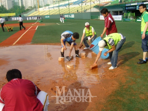 ▲폭우이후수작업으로일일이빗물제거를해야하는목동구장의현실태.사진│김현희기자