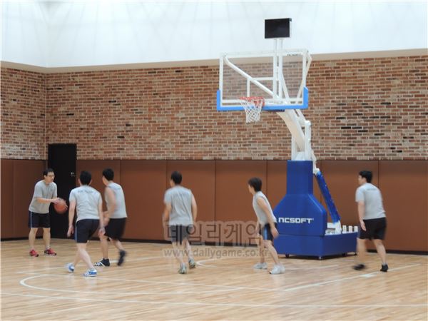 실내 코트에서 농구를 즐기는 직원들