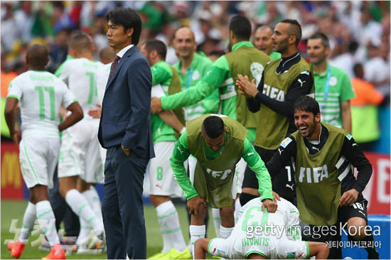 홍명보감독이골을허용한후망연자실한표정을짓고있다.그뒤에는알제리선수들이기뻐하고있다.(사진=ⓒGettyImages/멀티비츠제공)