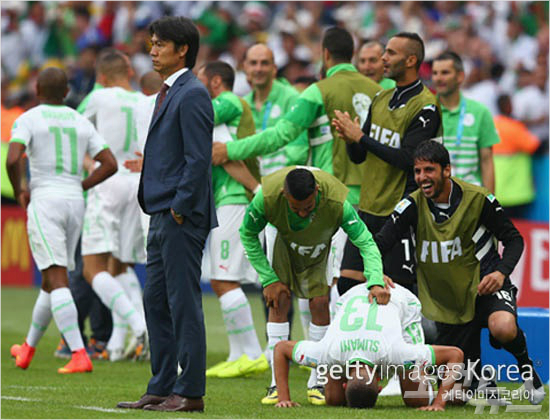 홍명보감독이선제골을허용한후망연자실한표정을짓고있다.그의뒤에서는골을넣은알제리이슬람슬리마니선수가기뻐하며절하고있다.(사진=ⓒGettyImages/멀티비츠제공)