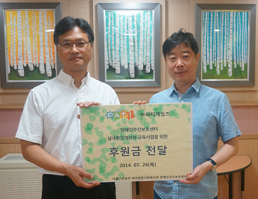 박기택 파티게임즈 이사(오른쪽)가 김범태 북부종합 사회복지관 관장에게 후원금을 전달하고 있다.