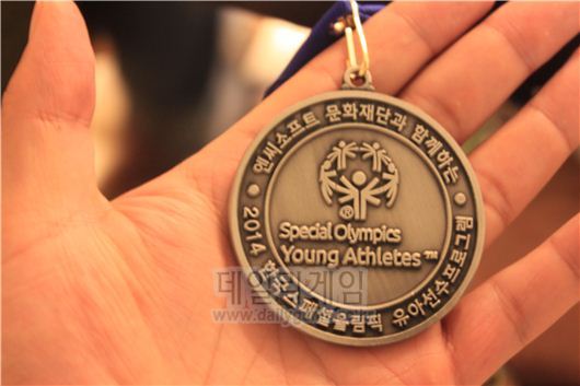엔씨소프트문화재단은 스페셜올림픽에 나갈 수 없는 7세 이하 유아와 중증 장애인을 후원한다. 이 프로그램을 마친 이들에게는 선수들과 같이 이러한 메달이 주어진다.